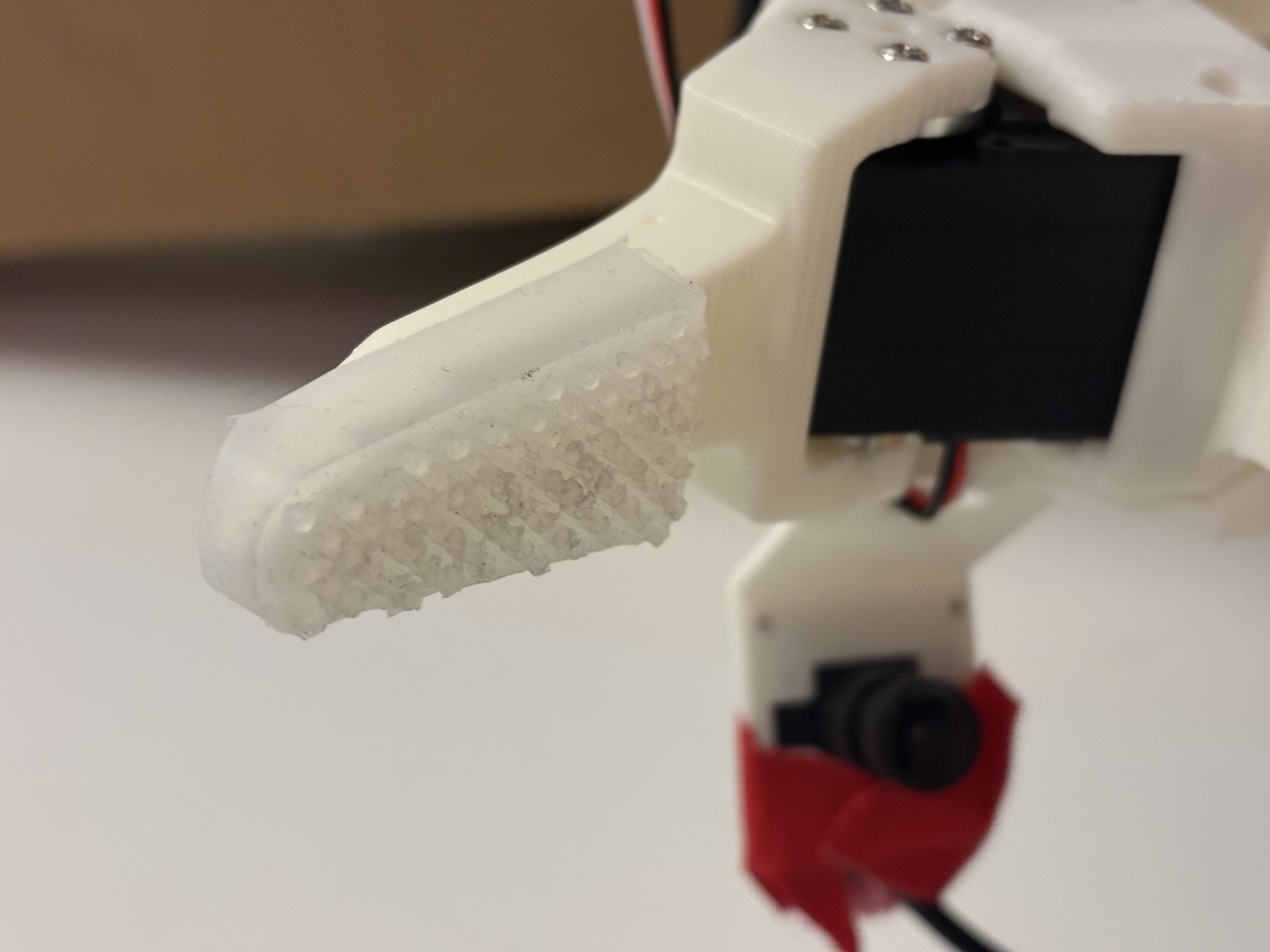 Fingertip close-up showing piezoresistive bump array and embedded camera