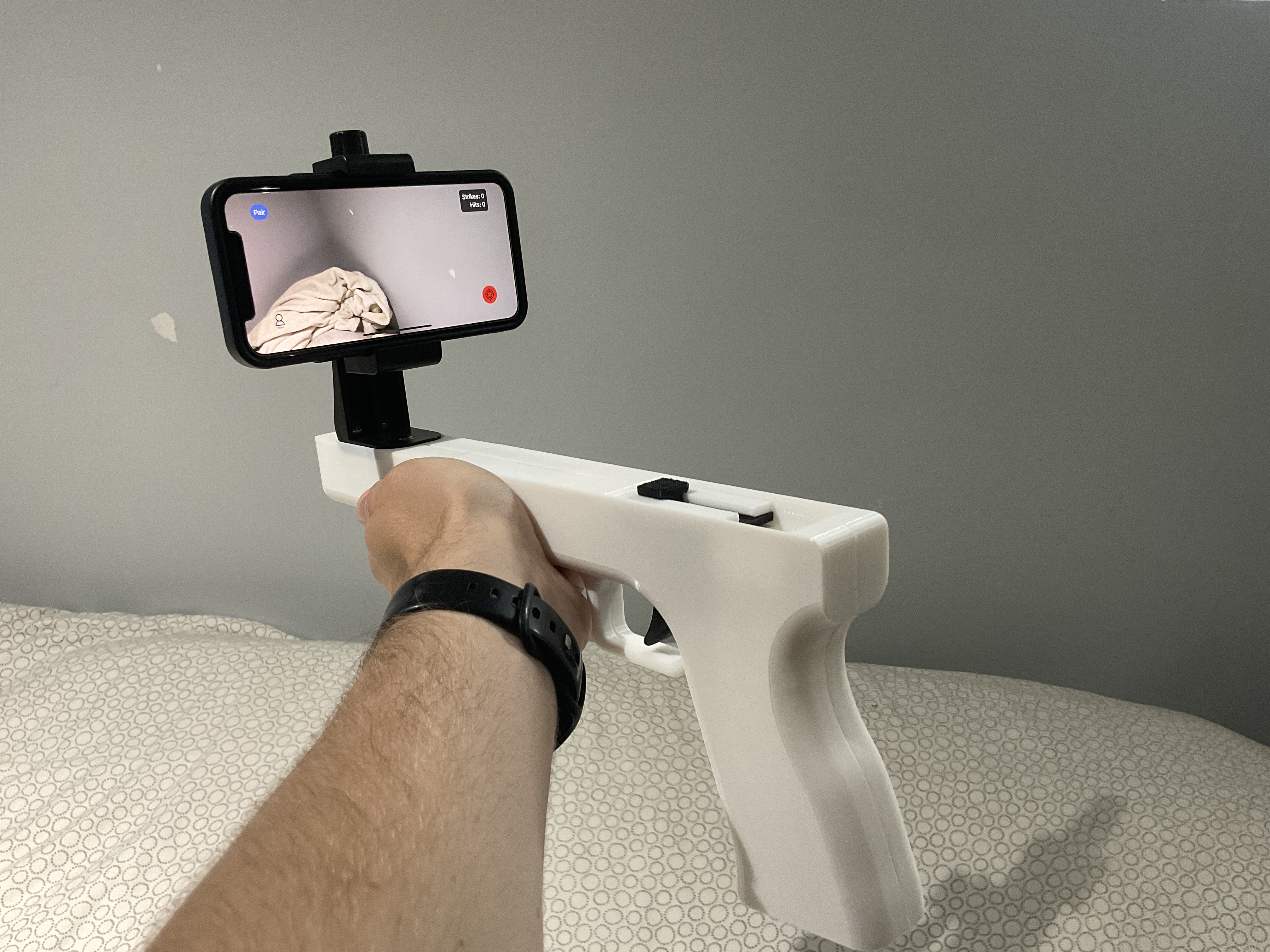 WarStrike controller held in hand with iPhone running the app